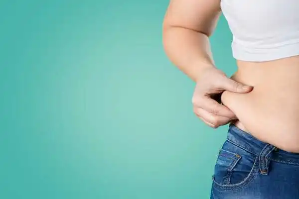 Image of woman pinching her love handles to show weight gain Uttoxeter